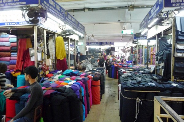 A tiny section of the fabric stalls in Dong Xuan Market complete with a trader using the bales as a bed